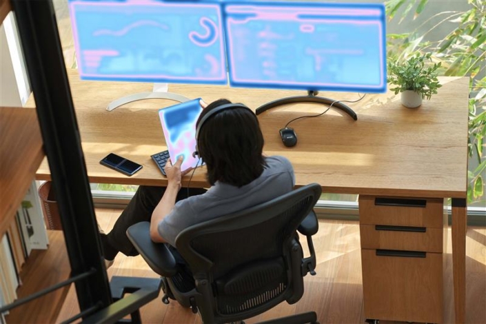 a-person-sitting-at-a-desk-with-a-computer